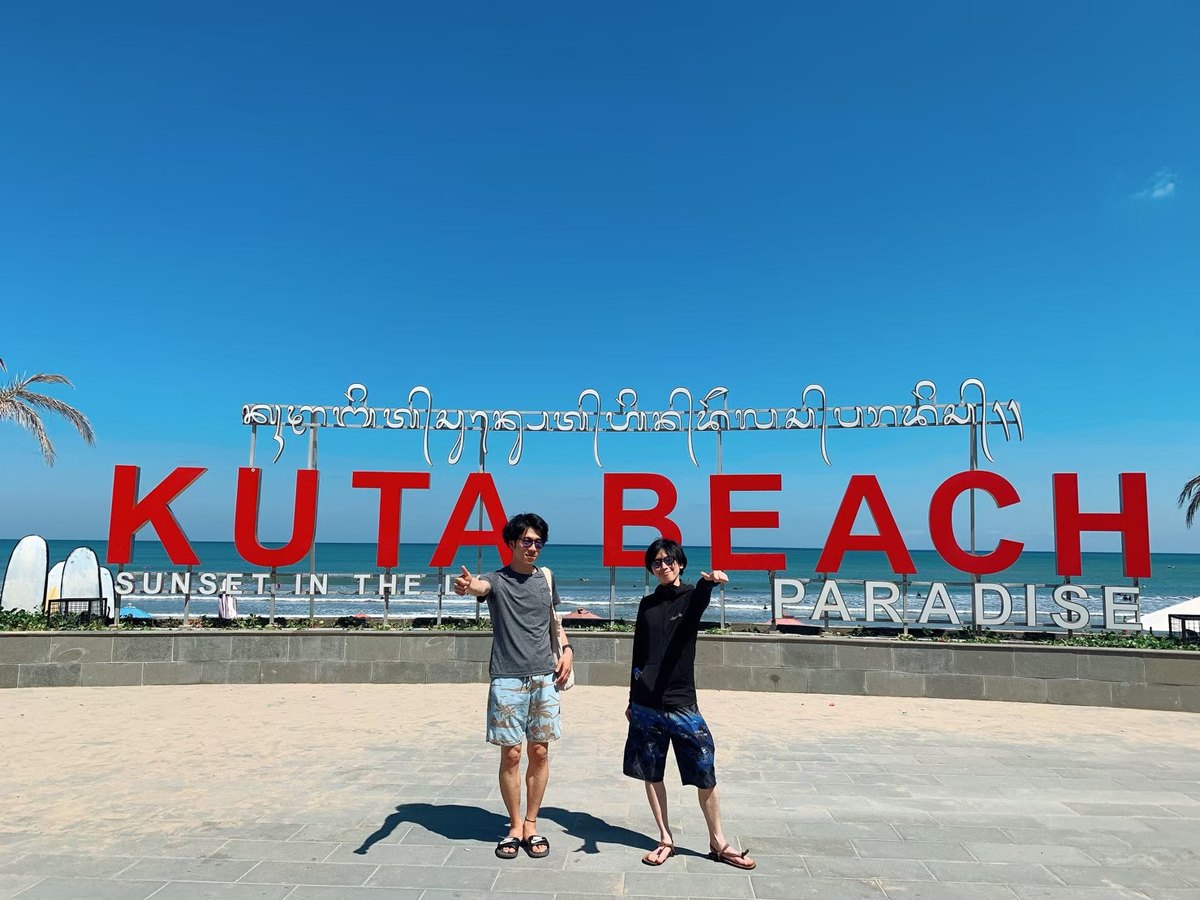 KUTA BEACHの看板と海を背景に撮った旅行写真